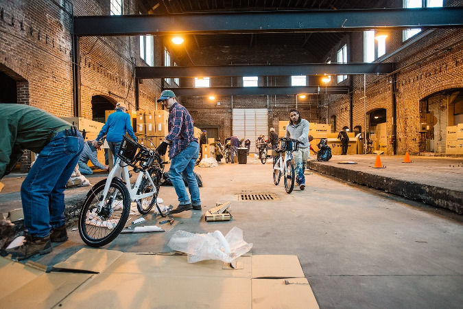 Volunteers work to unbox the 600 new Dash bikes in February.