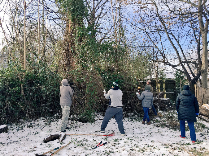 Volunteers work to clear debris from a lot in the Beltline neighborhood.