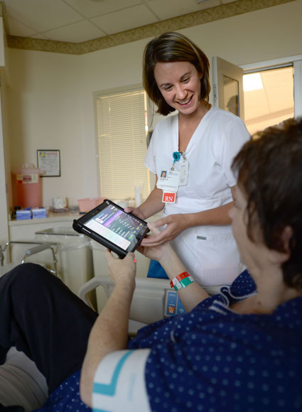 Baptist nurse Jessica Hall helps patient use My Chart Bedside tablet