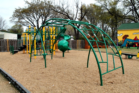 A playground at the main Knowledge Quest campus with the new stock house in the background.