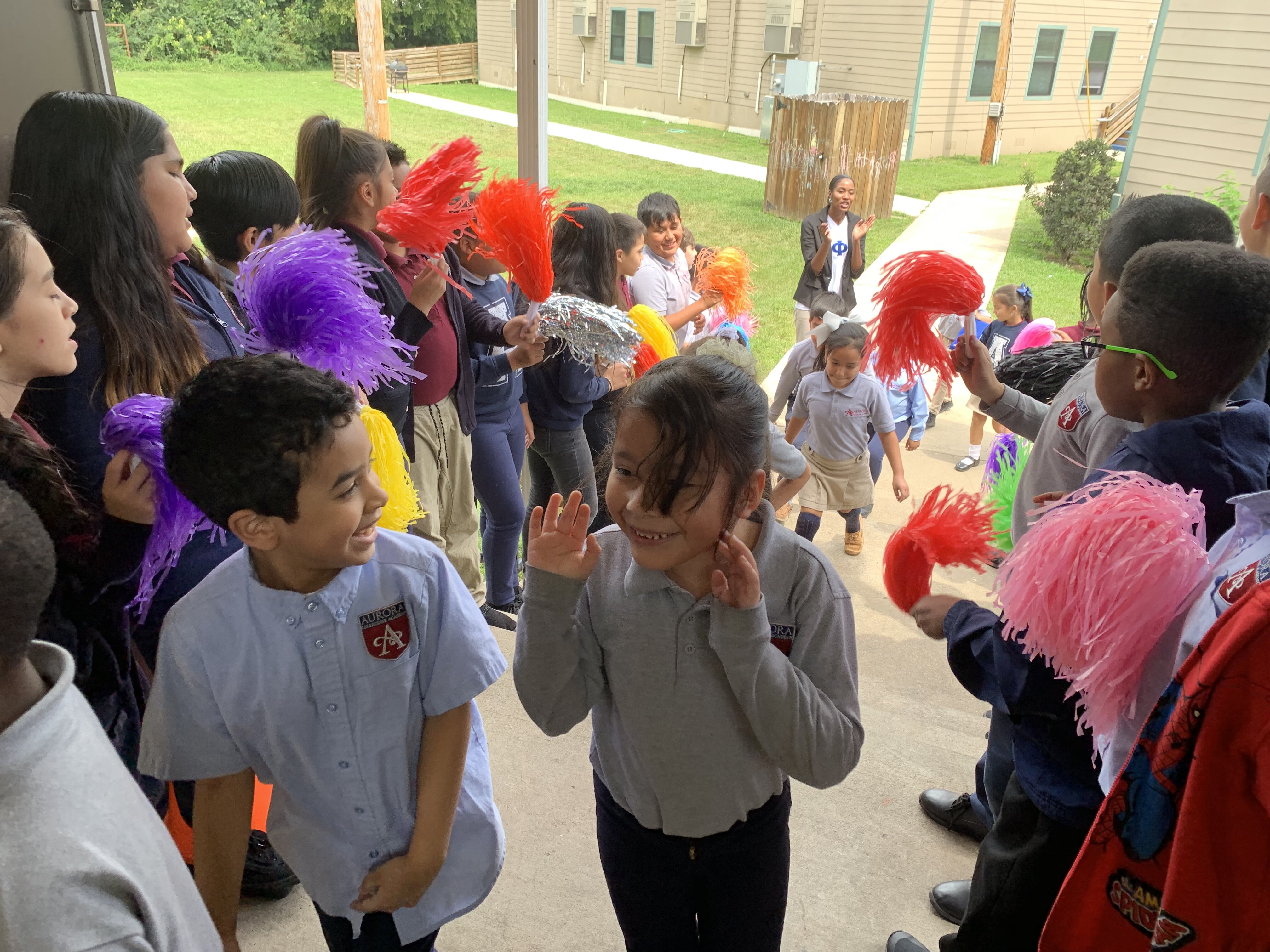 Fifth-grade scholars cheer on K-2 scholars as they head into their Friday Community Meeting. Gonzalo Munguia Lopez Jr. (center, left) and Yoselin Garcia (center, right) share an excited smile. (Cat Evans)