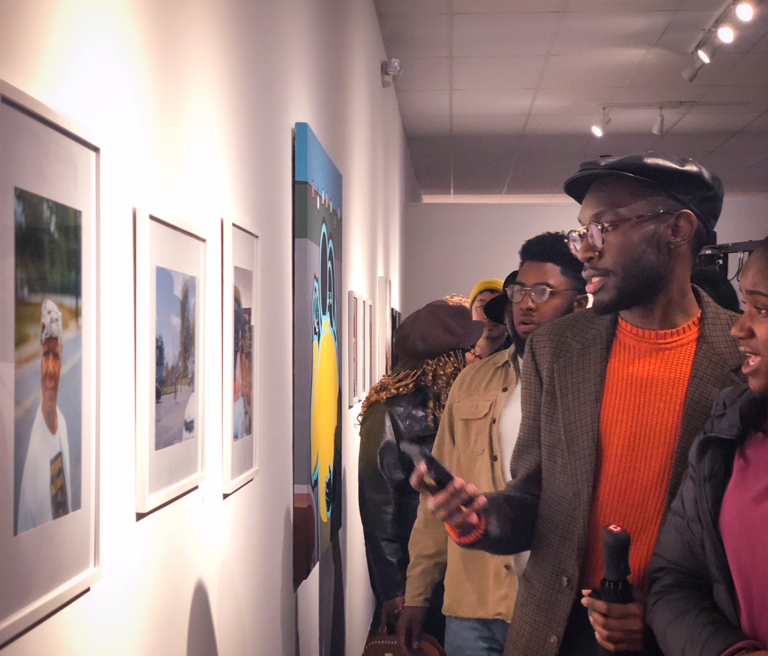 Guests discuss a set of photographs at The CMPLX grand opening. (Shelda Edwards)