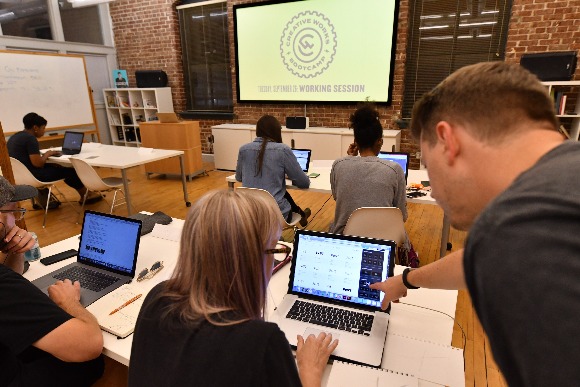  Creative Works Design Bootcamp student Jeannie Tomlinson-Saltmarsh works with Creative Works COO, Dan Price,​​​​ to finalize the logo for her neighborhood development project. 