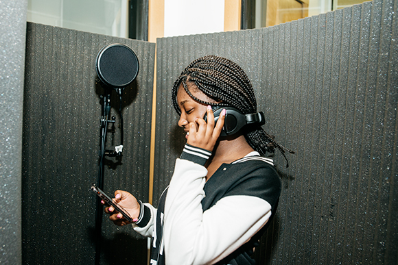 Mickele Bridges collaborates with other students to produce a song in Cloud901's recording studio.