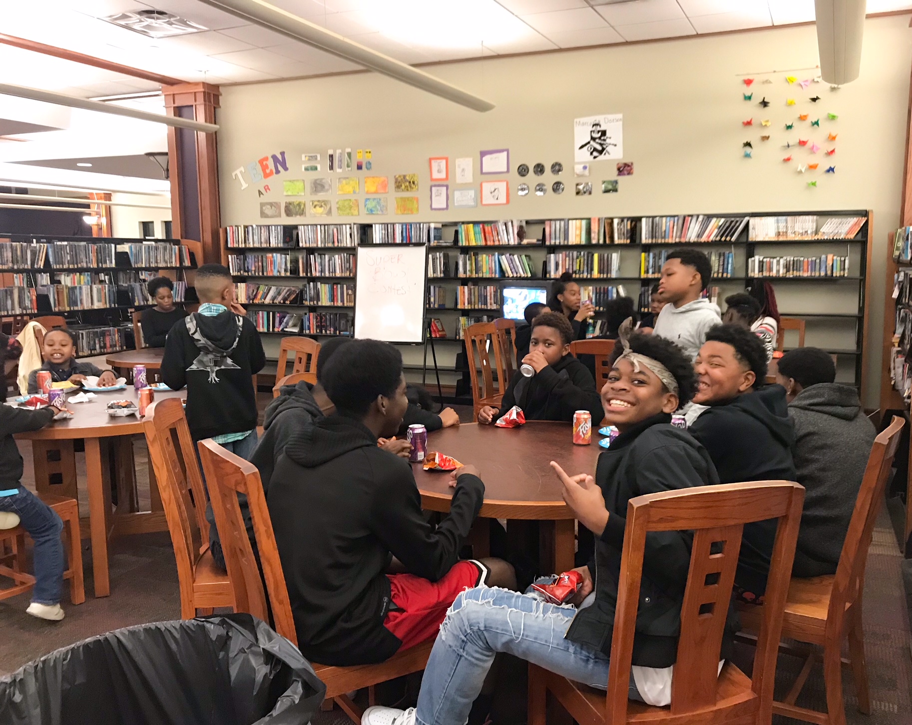 Teens and younger kids gather in the teen area around a small television set up just for them at the Whitehaven Library Super Sunday at The Haven event on February 3. (Cole Bradley)