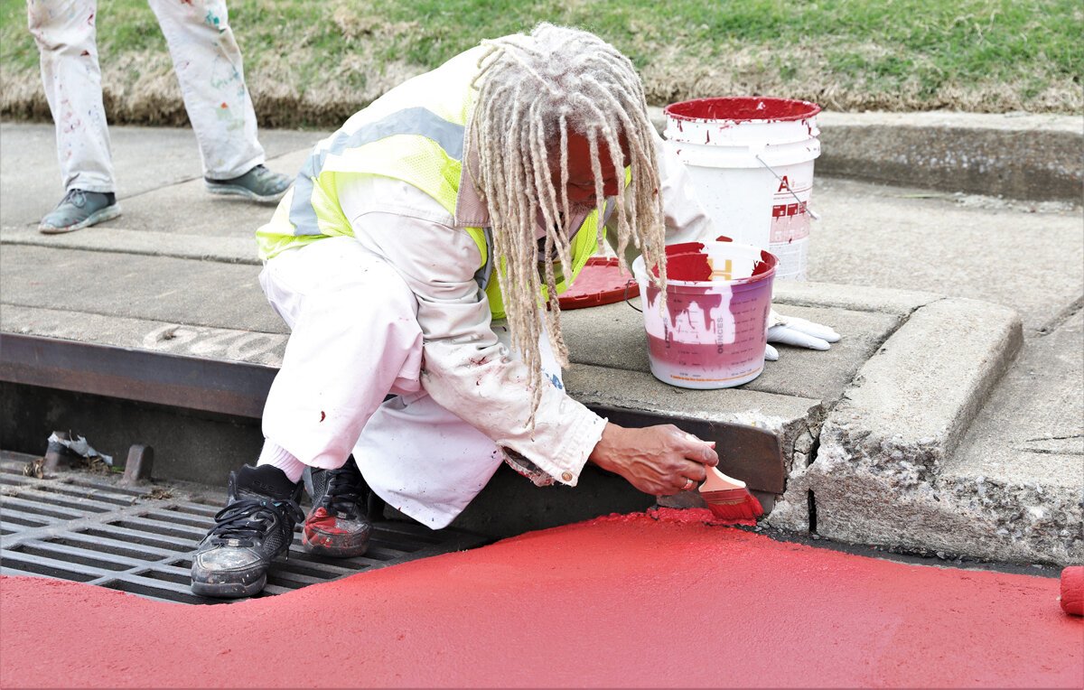 Crew members for the Heights CDC work on traffic calming features to complement the new bioswale construction at Tutwiler and National. (Reginald Johnson)