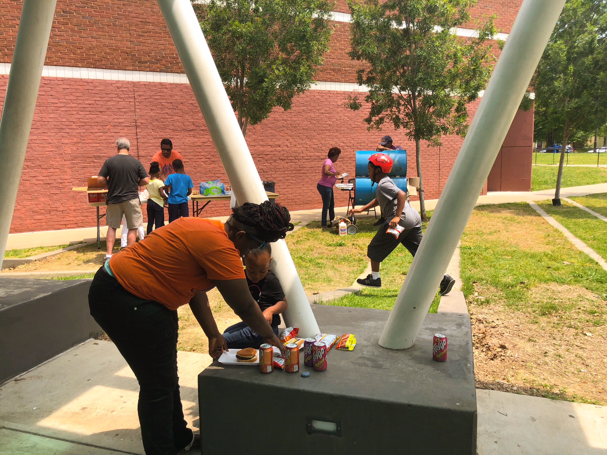 Community members take a break from the competition and enjoy free hot dogs and hamburgers prepared by David Yancey's father, David Yancey II. (Shelda Edwards)