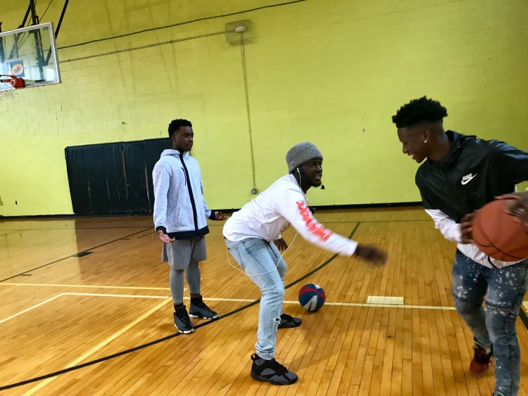 Los adolescentes y el personal juegan al baloncesto durante el tiempo de inactividad entre programas como clases de educación financiera y proyectos de servicio. (Cole Bradley)
