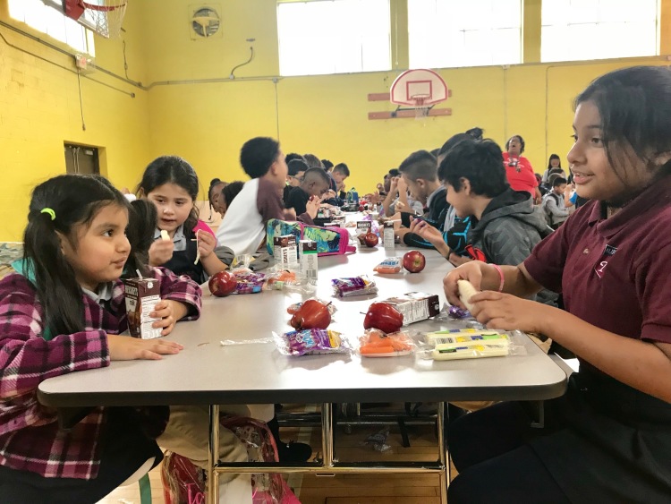 Los estudiantes hablan y comen una merienda del mediodía. (Cole Bradley)