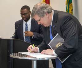 Paul Young (L) and Mayor Jim Strickland (R) sign a Green & Healthy Homes compact at a ceremony at the Benjamin Hooks Library on Nov. 30. (Lisa Buser)
