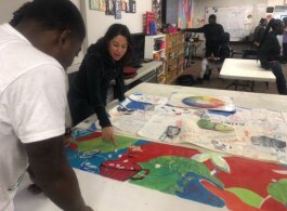 Yancy Villa-Calvo and Brandon Zuber (left) discuss design elements on a working draft of the mural that will be installed on the side of Whitten Brothers Hardware in Orange Mound. (A.J. Dugger)