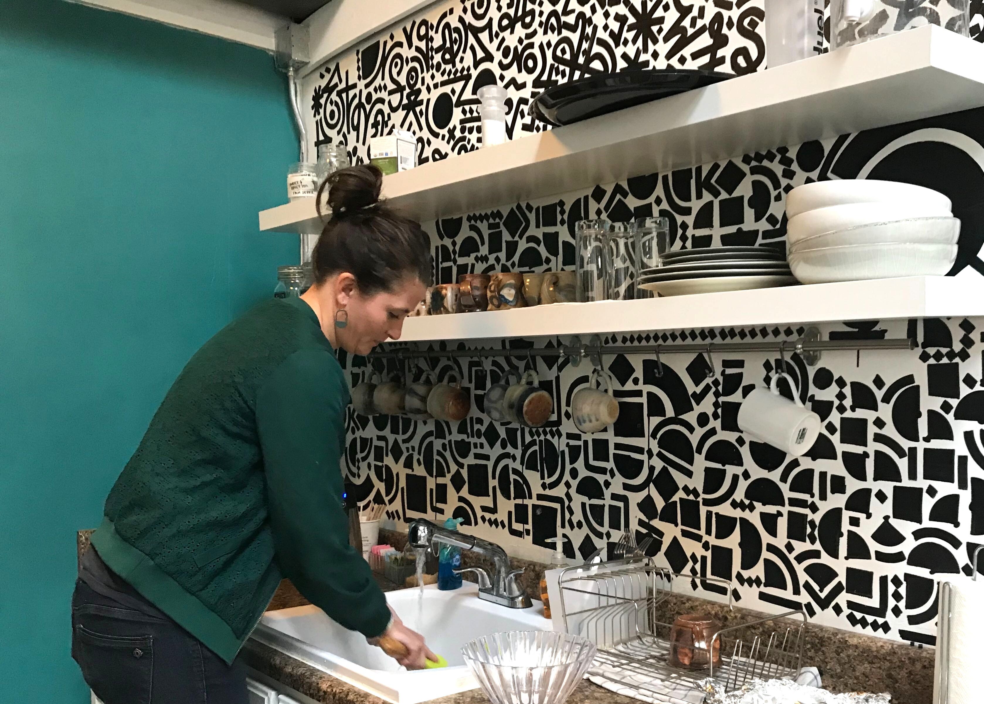 Co-owner Cat Peña washes a dish in Wonder / Cowork / Create's kitchen area. (Cole Bradley)