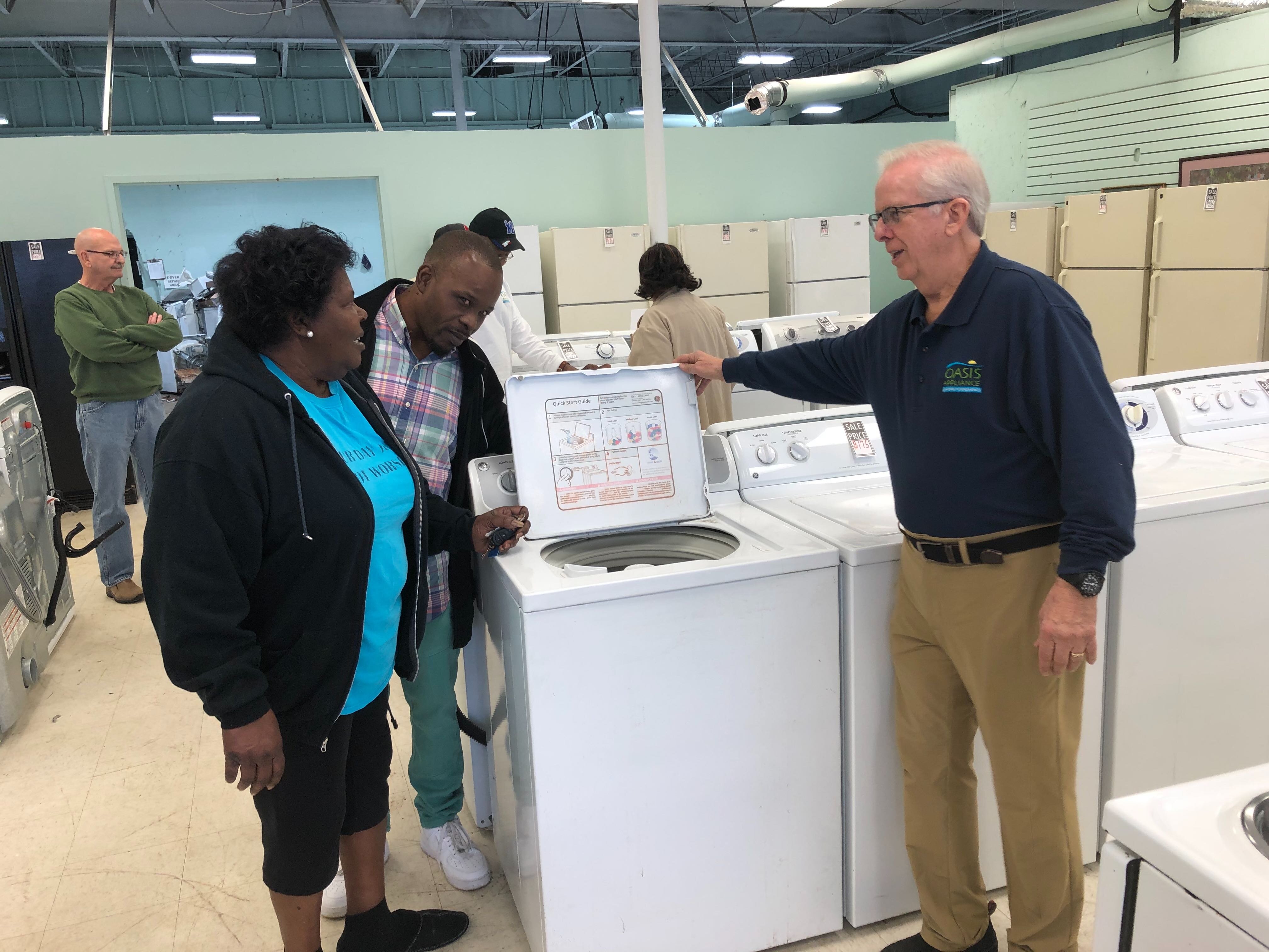 The Oasis Appliance store's strategic manager, Dana Driver (R), assists customers in selecting a new washing machine. (A.J. Dugger) 