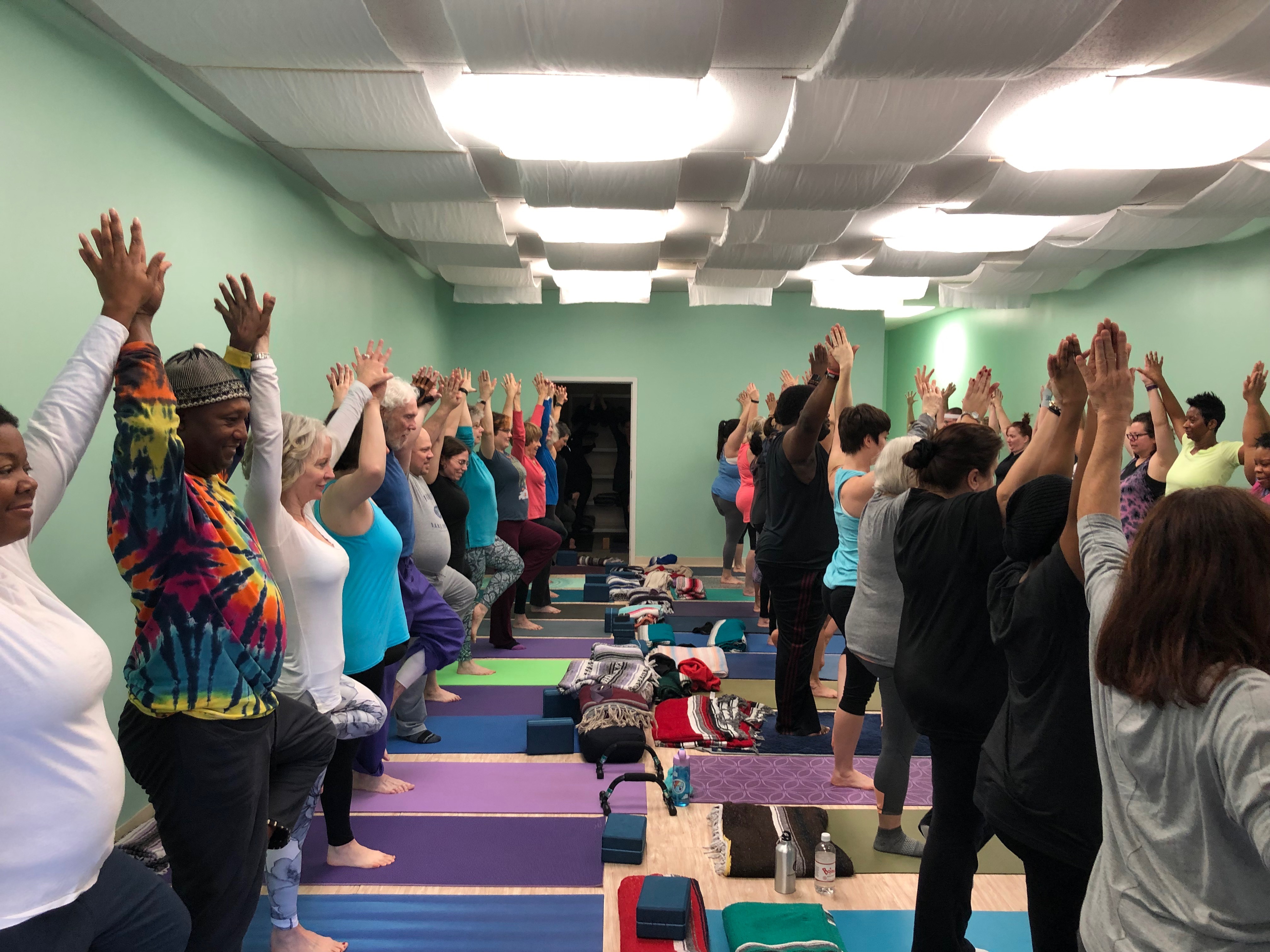 A diverse group of students hold a pose at Yolandrea Clark's Any Body Yoga studio in Midtown Memphis. (Shelby Black)