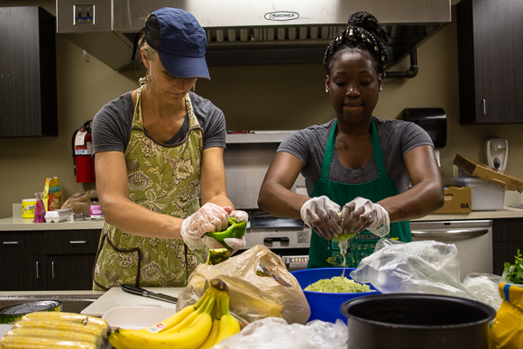 Kristin fox-Trautman and Charlena Branch working with food at Kaleidocope Kitchen in Binghampton.