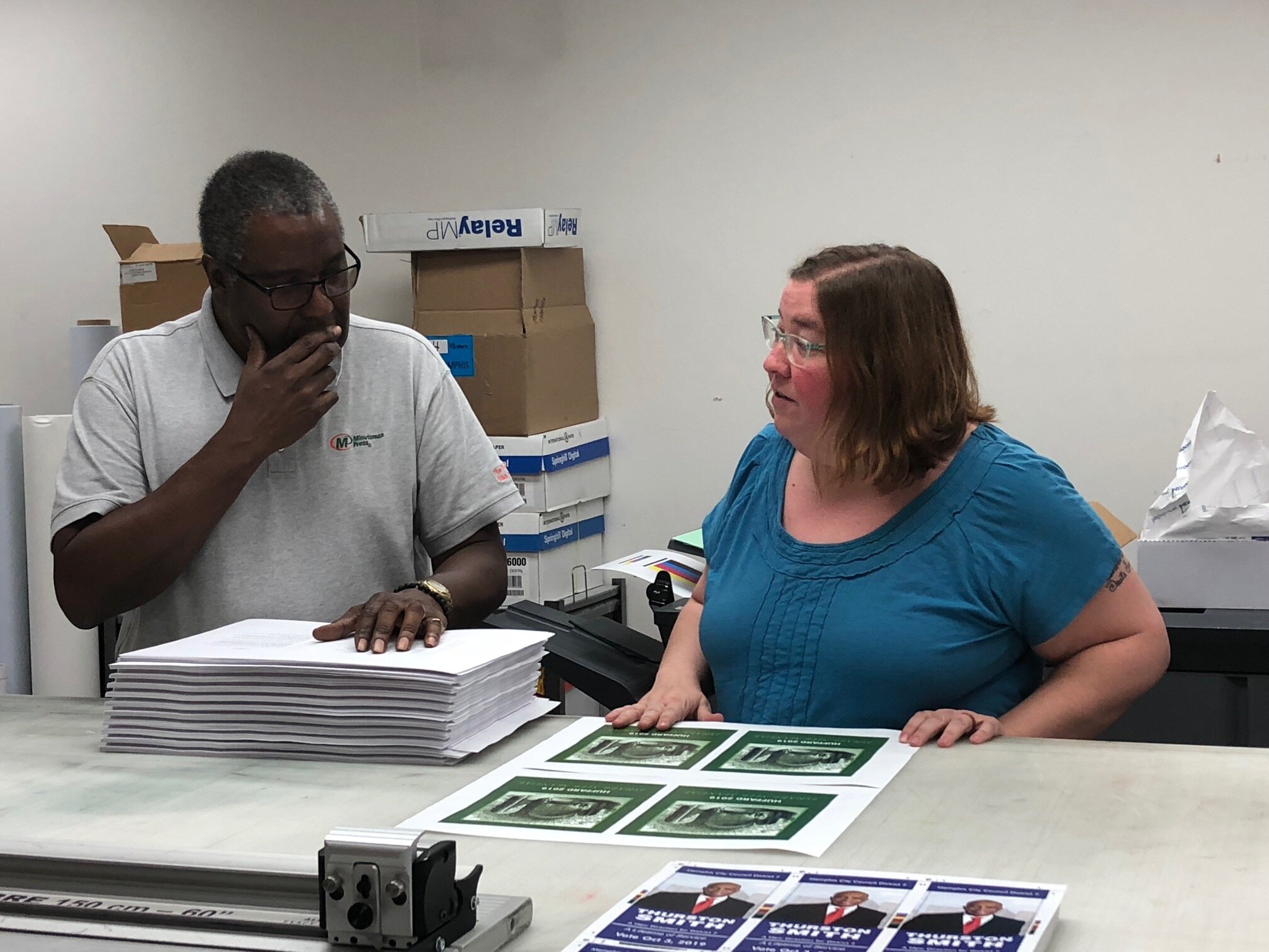 Al Harville (L) and Allison Hancock work together to finalize the design and layout on a client's order. (AJ Dugger III) 