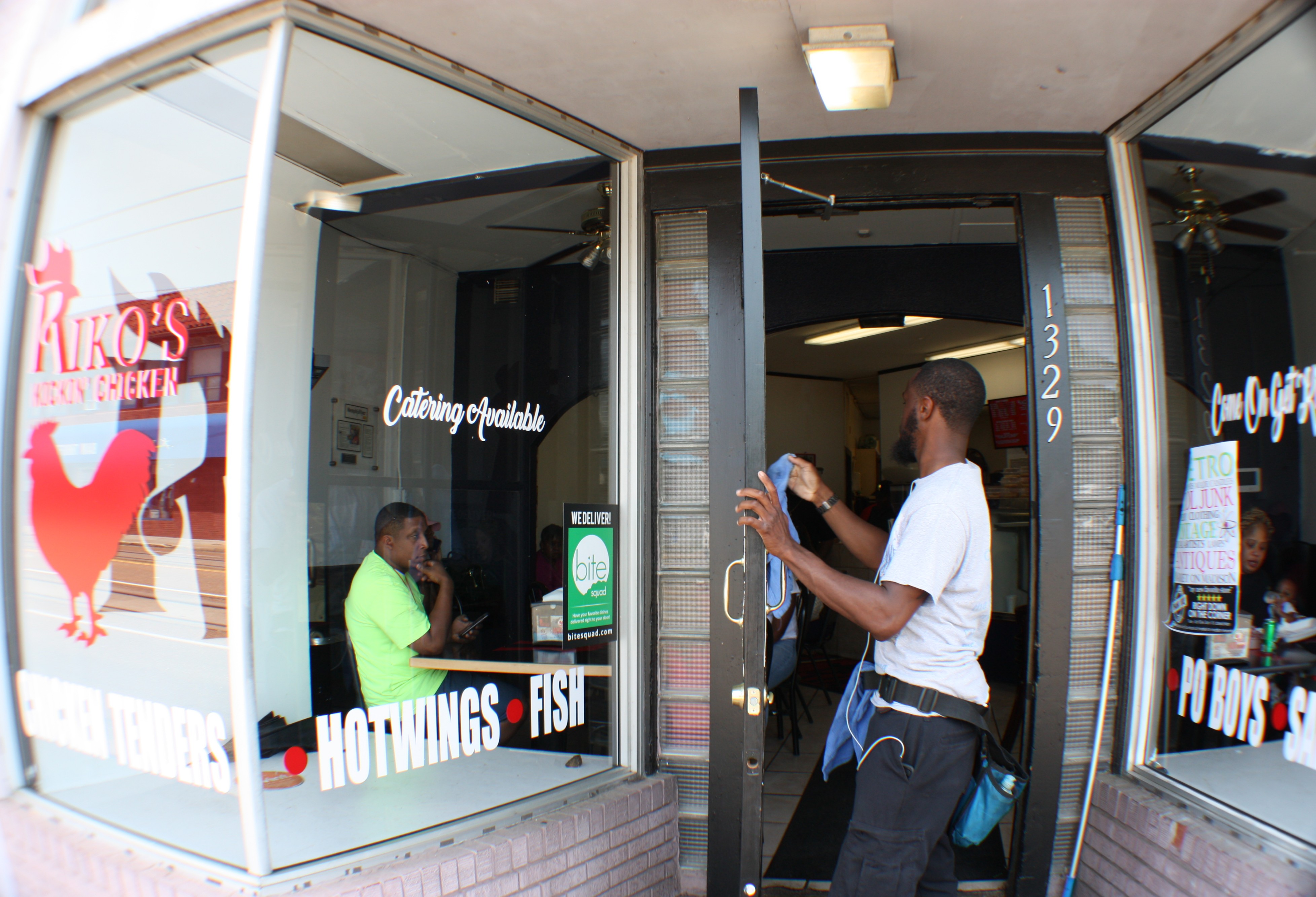 Walter Clark, owner of Outstanding Touch window services, puts the finishing touches on the door of Riko's Kickin Chicken, located at 1329 Madison Avenue. (Cole Bradley)