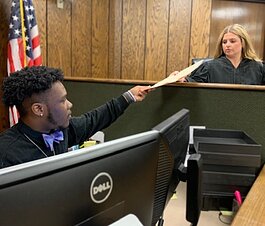 Community Court Clerk Darious Scott (L) hands a case file to Community Court Referee Lisa Harris, who will preside over the case. Community Court is a subsidiary of Shelby County Environmental Court. (Rob Brown)