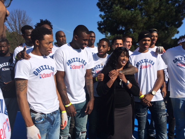 Dr. Andrea Miller, president of LeMoyne-Owen College poses for a photo with members of the school's basketball team. In October, they volunteered their time for the rehab at Chandler Park. (Rebecca Hutchinson)
