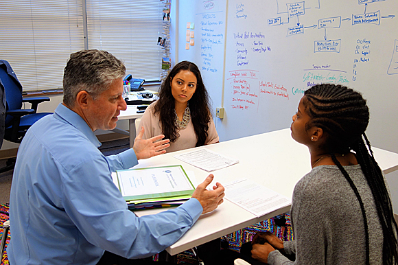 College students Cinthya Bolanos and Madisonne Cooper brainstorm with Scott Vogel.