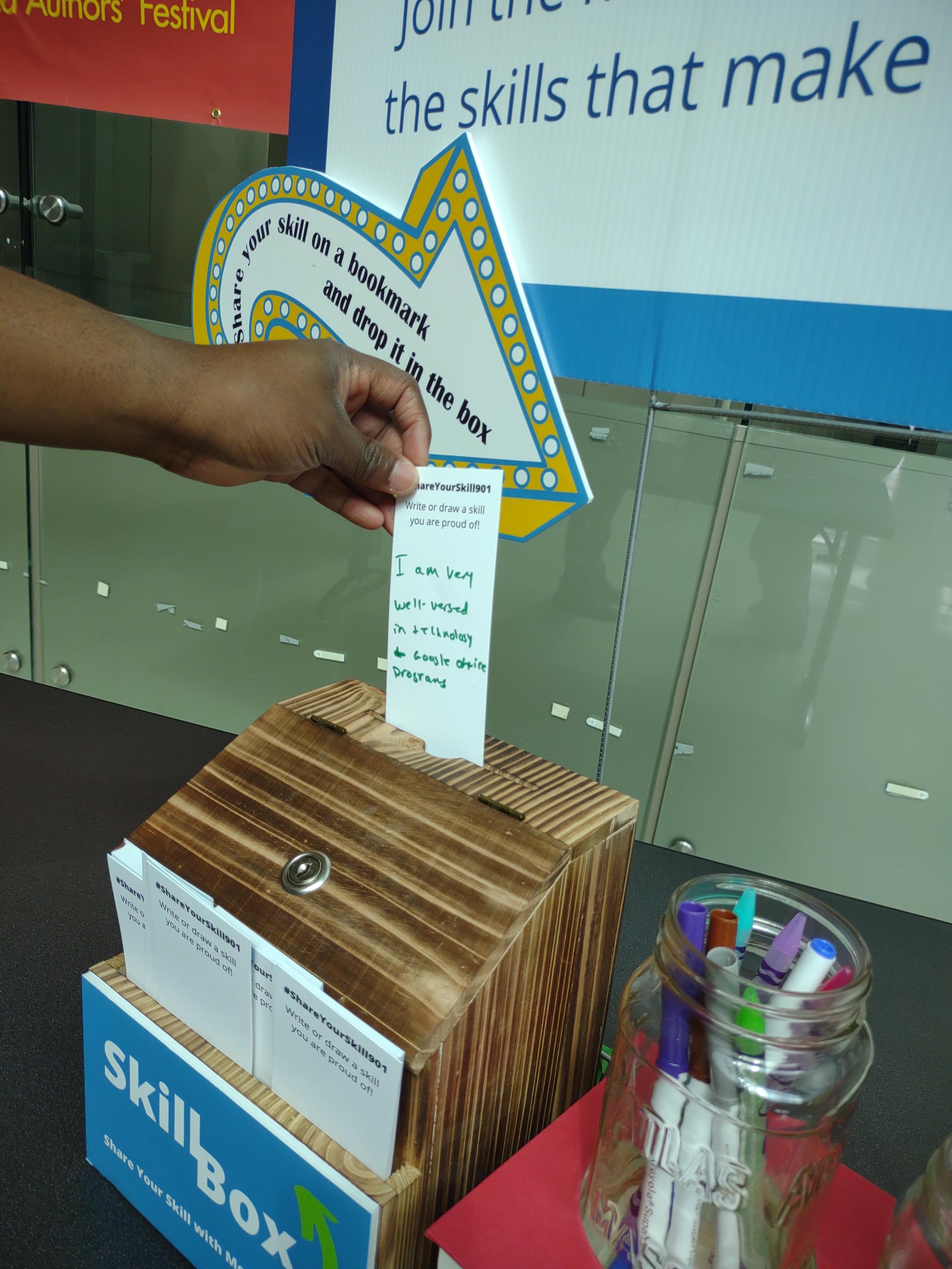 Darnell McCurdy, an employee at the Benjamin L. Hooks Library, puts a bookmark with his written skills in a box. (Photo courtesy of Literacy Mid-South)