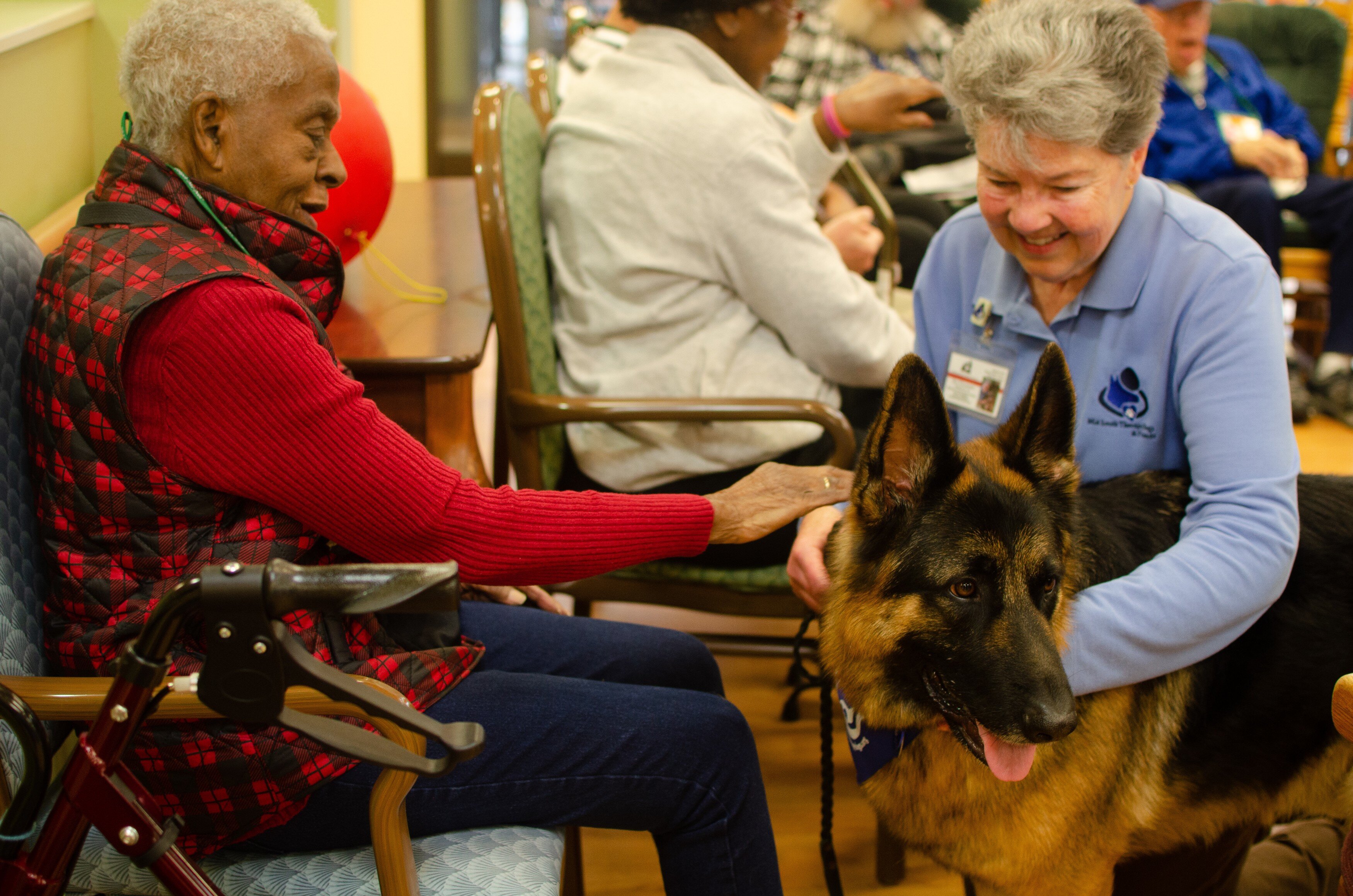 Batman the therapy dog helps Dorothy's Place clients suffering from Alzheimer's and dementia. Here client Lula pets Batman and talks with his handler, San Chambers. (Cat Evans)