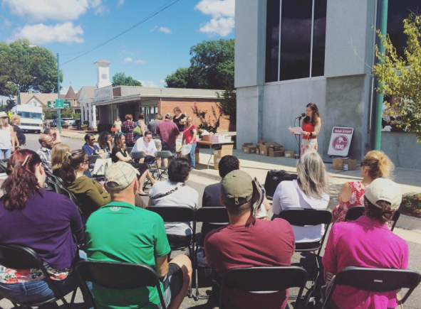 Heather Dobbins reads on Cooper Street during the street fair portion of the Mid-South Book Festival.