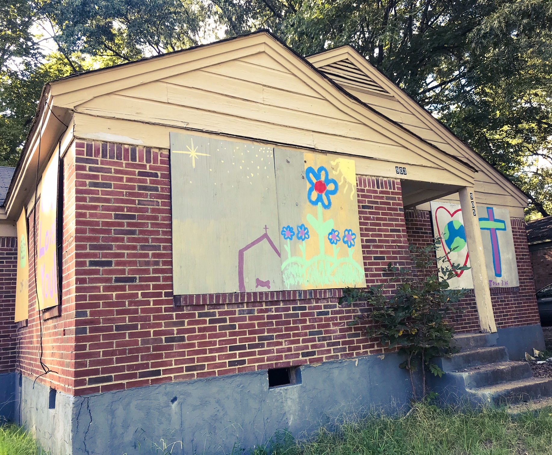 Community members boarded up a blighted house in Mitchell Heights and painted it with colorful artwork. (Cole Bradley)