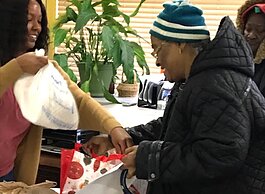 A Mustard Seed volunteer hands a Thanksgiving care package to a South Memphis resident. (Mustard Seed)