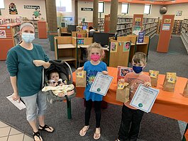 A family picks up activity sheets and grab-and-go craft kits at the North Branch Library. The kids are part of Memphis Public Libraries' strategy for helping kids with learning and literacy from home during the pandemic. (Memphis Library Foundation) 