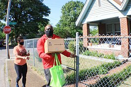 JUICE Orange Mound board members Kenya Holmes (L) and Broderick Conneser deliver supplies to a senior in Orange Mound. JUICE asked residents to text what supplies they needed and personalized orders before delivery via CAREavan. (Cole Bradley)