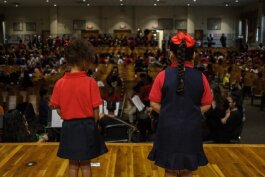 Two kindergarten students introduce their class song to the audience of Treadwell Elementary School as part of a Hispanic History Month celebration. (Renier Otto)
