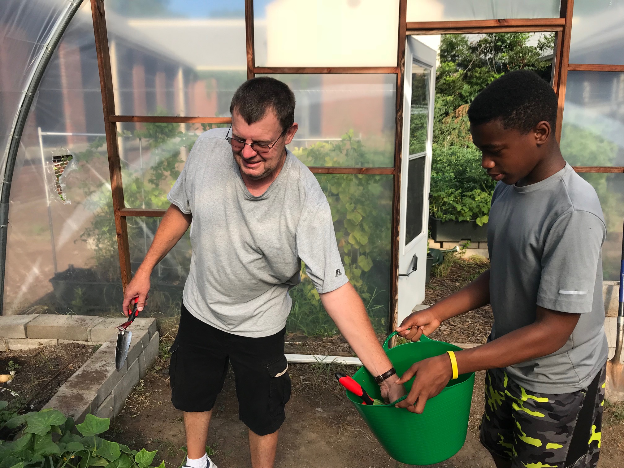 James Ritter, faculty member and manager of the Kingsbury garden program, discusses the pepper crop with student entrepreneur, Barak Muhammad. (Cole Bradley)