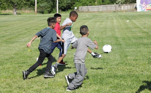 Children chase a soccer ball during an after-school game facilitated by Play Where You Stay. (Play Where You Stay)