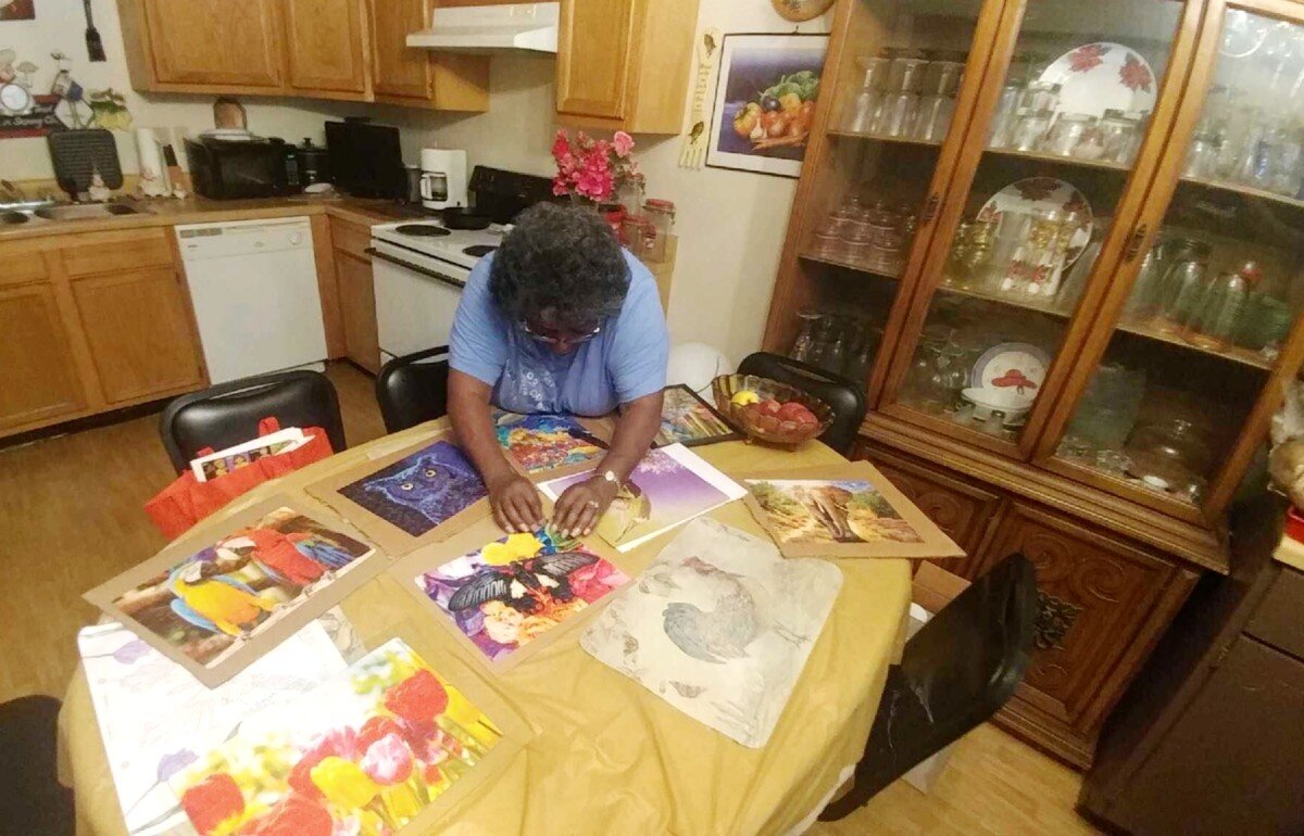 Derotha Payne-Obie mounts a recently completed puzzle at her dining room table. Prior to the pandemic, she attended the Lewis Senior Center. It closed in March under local and state mandates. (Tamara Cunningham)