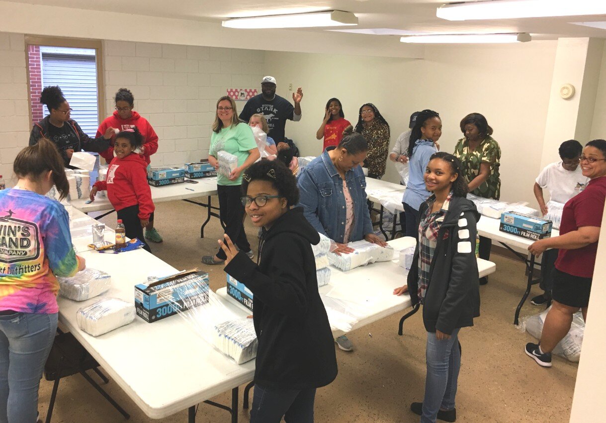 Before the coronavirus pandemic, volunteers with Sweet Cheeks Diaper Ministry worked together at a 'wrapping party' to bundle diapers for the families they serve. (Submitted)