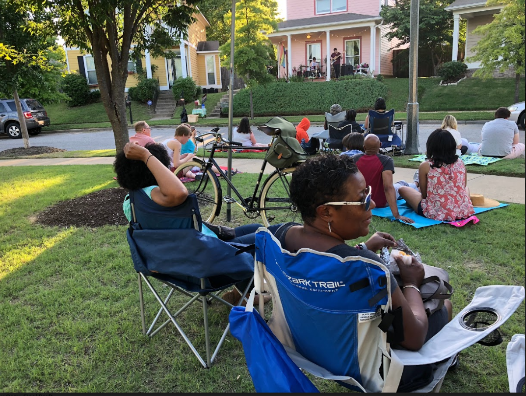 Uptown Community Association member Tanja Mitchell enjoys the concert with her friends. It was Mitchell who first proposed applying for the grant that made the porch series possible. (Cole Bradley)