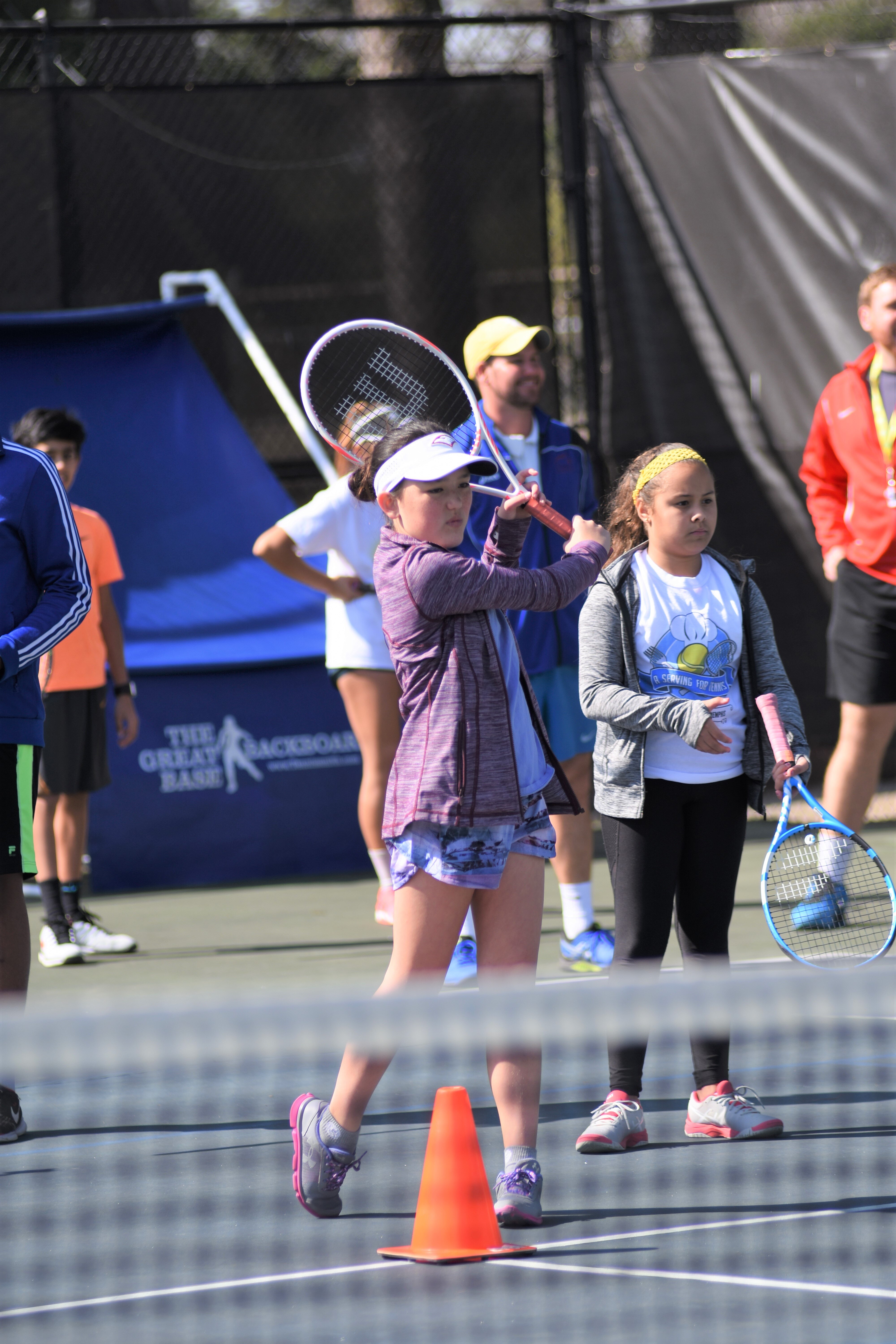 Shelby Callaghan, front left, practices hitting the tennis ball while Dianik Baldoquin waits her turn at Tennis Memphis youth program. (Tennis Memphis)