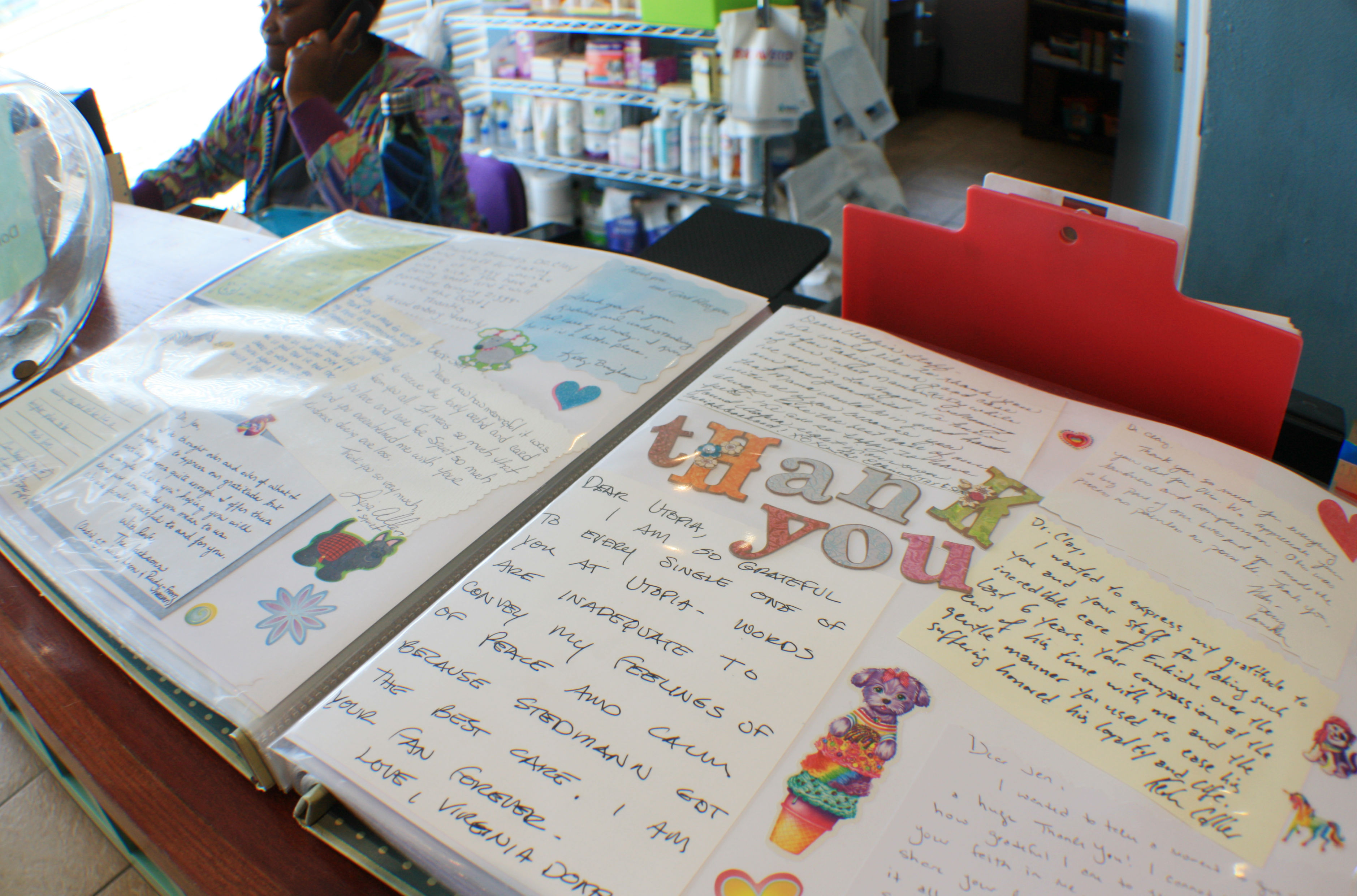 A scrapbook filled with photos of happy patients, thank you notes from grateful families, awards and media coverage sits open on the front desk of Utopia Animal Hospital located at 1157 Madison Avenue in Madison Heights. (Cole Bradley)