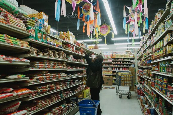 A shop reaches for an item off a top shelf at the Viet Hoa Food Market in Madison Heights. (High Ground News) 