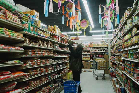 A shop reaches for an item off a top shelf at the Viet Hoa Food Market in Madison Heights. (High Ground News) 